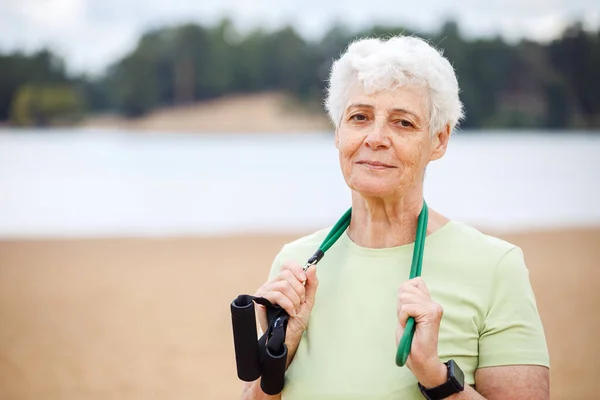 Gülümseyen Yaşlı Kadın Spor Giyer Sabahları Plajda Egzersiz Yaparken Lastik — Stok fotoğraf