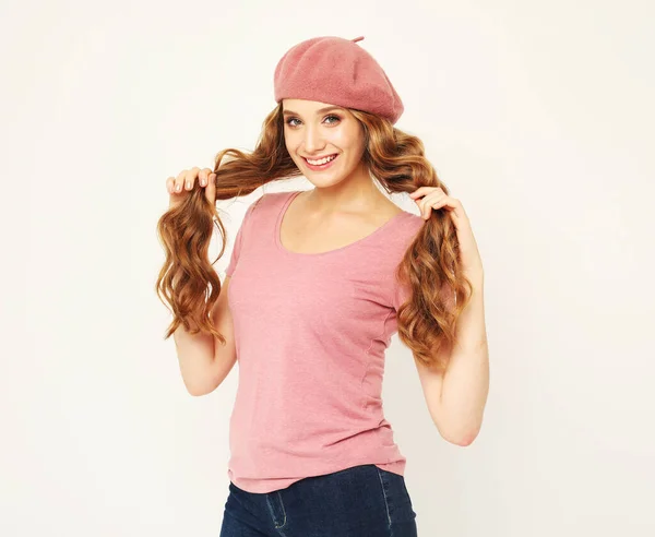 美丽的年轻女子 留着长长的波浪形头发 灰色背景上戴着粉色贝雷帽 — 图库照片
