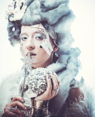 Elinde sihirli değnek ve noel balosu olan gümüş peruklu Kış Güzellik Kadını portresi. Kar Saçlı ve Makyajlı Güzel Moda Modeli Kadın. Kış Kraliçesi. Noel Kadını.