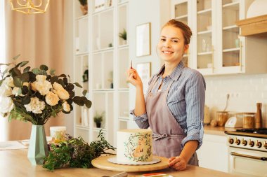 Pasta şefi kadın mutfakta pasta süslüyor. Yiyecek konsepti.