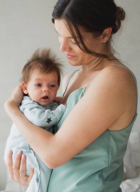 Sevgi dolu anne, yeni doğmuş bebeğini evde taşıyor. Yaşam tarzı ve aile kavramı.