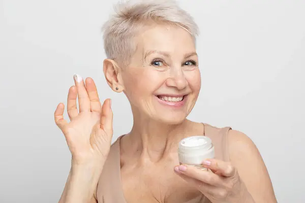 Smiling 60S Middle Aged Mature Woman Putting Tightening Facial Cream — Stock Photo, Image