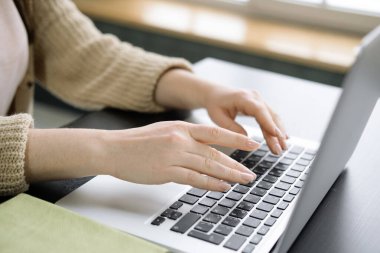 Modern dizüstü bilgisayar klavyesinde yazı yazan kadınların ellerini kapatın ve cihaza not alın. İş adamları konsepti.