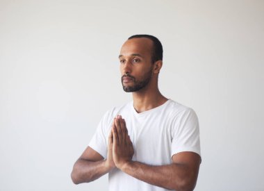 Genç yakışıklı afro adam zihnine konsantre oluyor, meditasyon yapıyor, yoga yapıyor, nefes egzersizi yapıyor stresi azaltıyor..