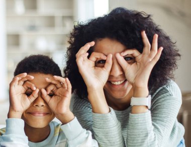 Mutlu, çok ırklı 6 'lı yaşlarda, kaygısız Afrikalı Amerikalı annesiyle oynayan, parmaklarıyla komik suratlar yapan çocuk. Yaşam tarzı ve insan kavramı.