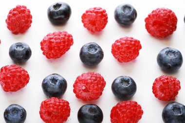 Beyaz arka planda izole edilmiş çeşitli taze meyveler. Ahududu ve yaban mersini, yaklaşın..