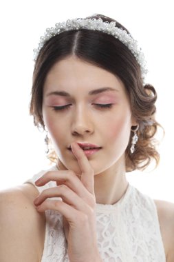 Mücevherler, lüks, düğün ve insanlar konsepti: Saçında muhteşem diyabeti olan genç gelin beyaz arka planda izole edilmiş, yakın plan portresi