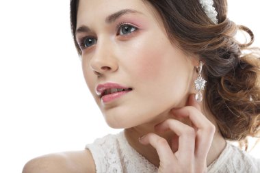 Göz kamaştırıcı diyademiyle şık bir gelin. Beyaz arka planda genç bayan modelin stüdyo portresi.