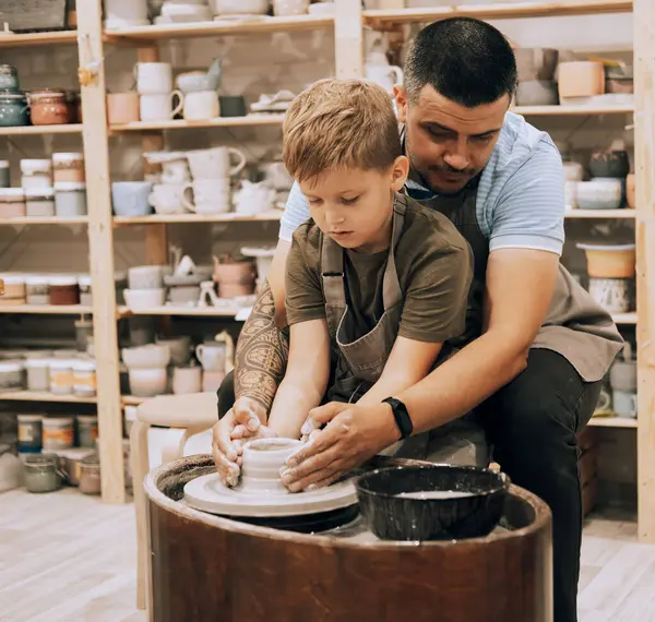 陶器のクラスで陶器の鍋を作る若者と小さな少年を自信を持って ライフスタイルと人々のコンセプト — ストック写真