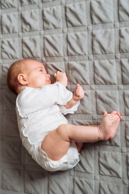 Küçük bebek uyurken yatakta uzanıyor.