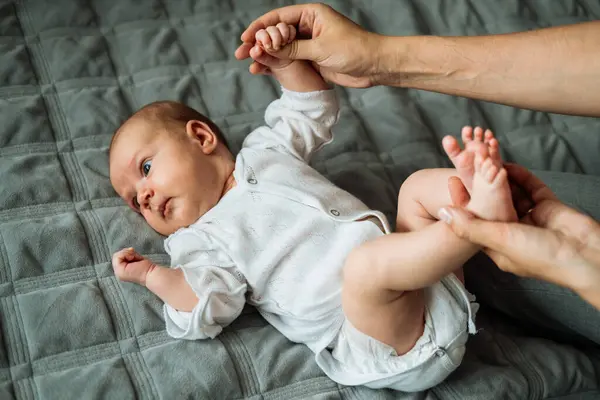 Pequeño Bebé Yace Sobre Manta Madre Sostiene Sus Manos Piernas — Foto de Stock
