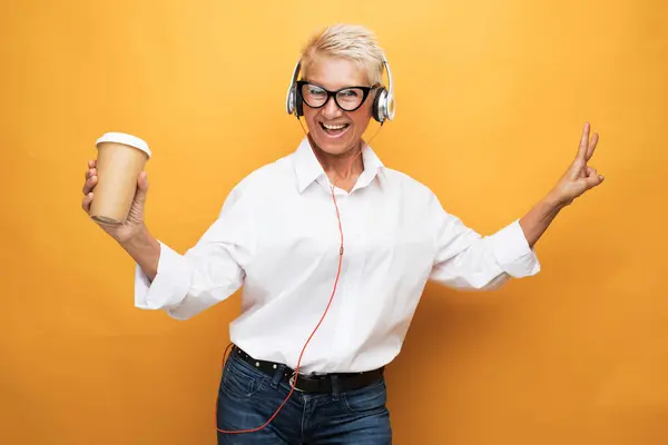 Cheerful Smiling Pensioner Woman Short Haircut Listens Music Holds Glass — Stock Photo, Image