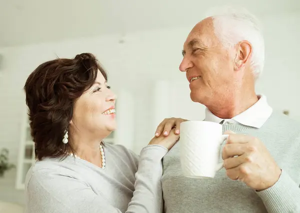 Happy Elderly Couple Drinking Coffee Kitchen While Sitting Table — Stock Photo, Image