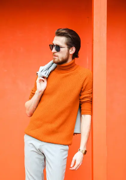 Stilvoller Junger Mann Orangefarbenem Pullover Und Sommeranzug Und Sonnenbrille Vor lizenzfreie Stockfotos