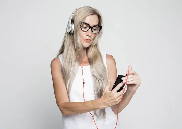 Ηλικιωμένη Γυναίκα Μακριά Μαλλιά Φορώντας Γυαλιά Ακούγοντας Μουσική Smartphone Απομονωμένο Φωτογραφία Αρχείου