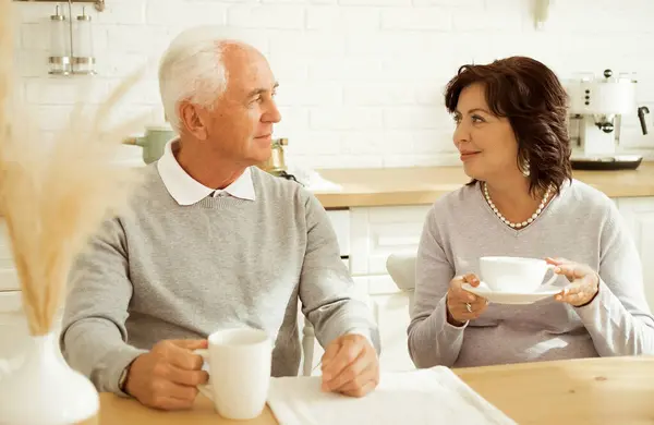 Mutlu Yaşlı Çift Masada Otururken Mutfakta Kahve Içiyor Telifsiz Stok Imajlar