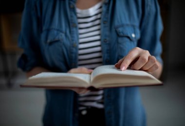 Elinde açık bir kağıt tutan kadın, kitapçıdan en çok satan roman konseptini okuyor evde boş zamanların hobisi modern edebiyatın keyfini çıkarıyor, manzarayı kapatıyor.