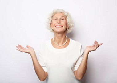 Emotion, lifestyle and old people concept: Portrait of happy smiling mature woman over white background.
