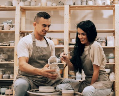 Genç bir çift çömlek atölyesinde çalışıyor. Vazo boyuyorum..