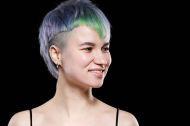 Şık kısa saç kesimi ve renkli saç boyası olan güzel bir genç kadın. Mavi-yeşil saçlı. Siyah arkaplan üzerine yakın plan portre.