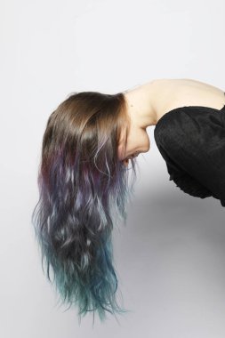 Çok renkli kıvırcık saçlı, saçları güzel dalgalar halinde dalgalanan genç bir kadın. Kapat..