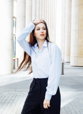 Şehirde şık esmer bir kadın var. Uzun saçlı genç bayan model beyaz gömlek giyiyor..