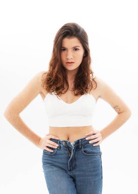 Stüdyoda beyaz arka planda poz veren uzun siyah kıvırcık saçlı model.