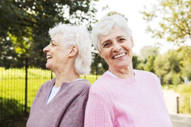 Bir yaz günü parkta gülen iki yaşlı kız kardeş. Yaşam tarzı kavramı.