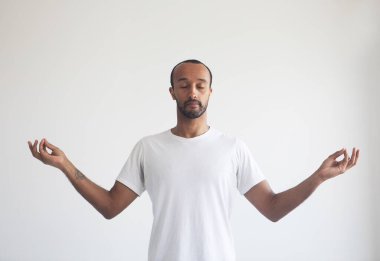 Genç afro adam zihnine konsantre oluyor, meditasyon yapıyor, yoga nefes alma tekniği stresi azaltıyor. Yaşam tarzı kavramı.