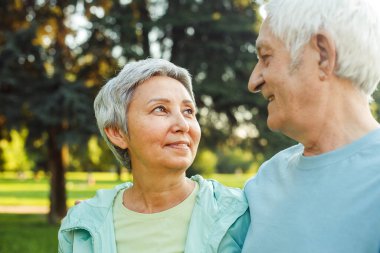 Parkta yaz yürüyüşüne çıkmış yaşlı bir çift. Çokuluslu evlilik. Yakın plan portreler. Yaşam tarzı kavramı.
