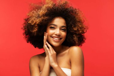 Kırmızı arka planda güzel bir makyajı olan genç Afrikalı kadın modelin portresi. Portreyi kapat.