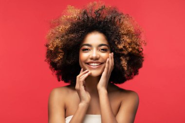 Kırmızı arka planda güzel bir makyajı olan genç Afrikalı kadın modelin portresi. Portreyi kapat.