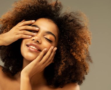 Güzel esmer, kıvırcık saçlı, gözleri kapalı ve elleri yüzüne yakın bir kız. Portreyi kapat.