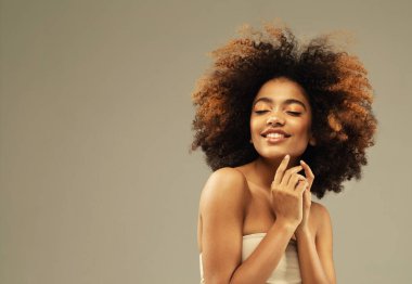 Güzel esmer, kıvırcık saçlı, gözleri kapalı ve elleri yüzüne yakın bir kız. Portreyi kapat.