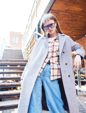 Bir sonbahar günü merdivenlerde poz veren şık genç bir bayan model..