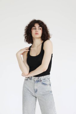 Kotlu ve beyaz tişörtlü güzel bir kadın model beyaz arka planda poz veriyor..