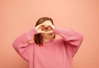 Şişman kadın, parmaklarıyla, kalp figürüyle sevgilisine sevgi yolluyor.