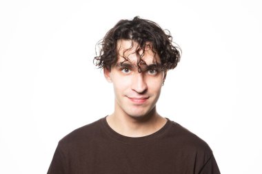 Beyaz arka planda kameraya bakan esmer bir adamın portresi.