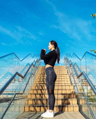 Genç ve sportif bir kadın sabahın erken saatlerinde merdivenlerde egzersiz yapıyor..