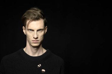 Siyah arka planda poz veren yakışıklı genç adamın yakın plan portresi..