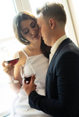 Genç bir çift şarap içip mutluluklarına gülümsüyor. Hoş insanlar konsepti.