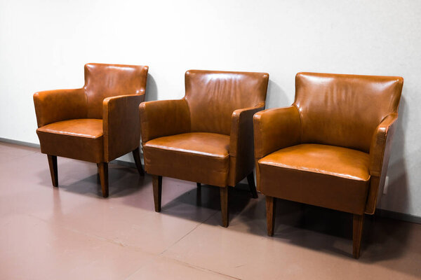 Три кожаных кресла у стены