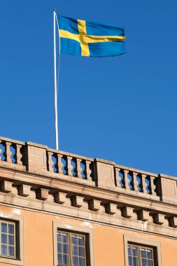 Mavi gökyüzü olan bir çatıda İsveç bayrağı