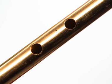 Beyaz arkaplanı olan teneke bir ıslıktaki delikler