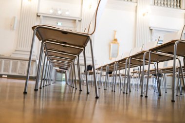 Büyük bir odada sıra sıra sandalye.