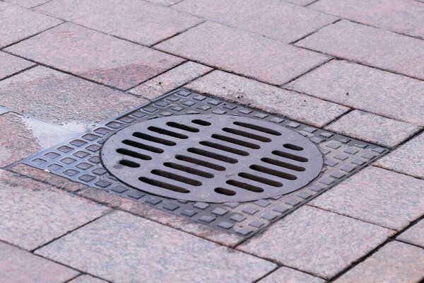 Крышка люка на тротуаре