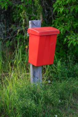 Kırmızı plastik posta kutusu dışarıda.