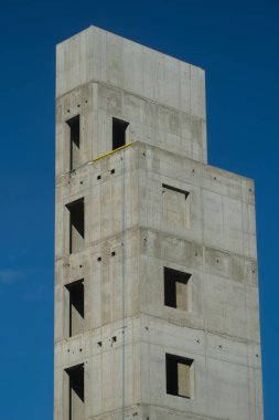 Mavi gökyüzü olan yüksek katlı bir bina.