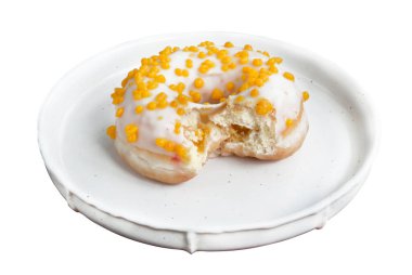 Beyaz tabakta sarı soslu ısırık çöreği.