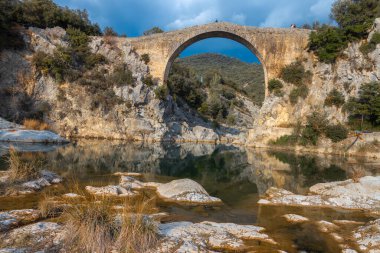 Katalonya, İspanya 'daki eski bir köprü Pont de Llierca manzarası. Kum taşı levhalarla döşenmiş bu güzel köprü 14. yüzyıldan beri kullanılıyor..